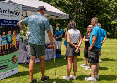 4 golfers check out the Early Years program booth set up by Archway