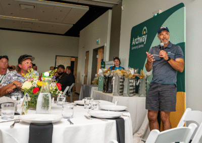 Mike speaks in front of a crowd of dining golfers